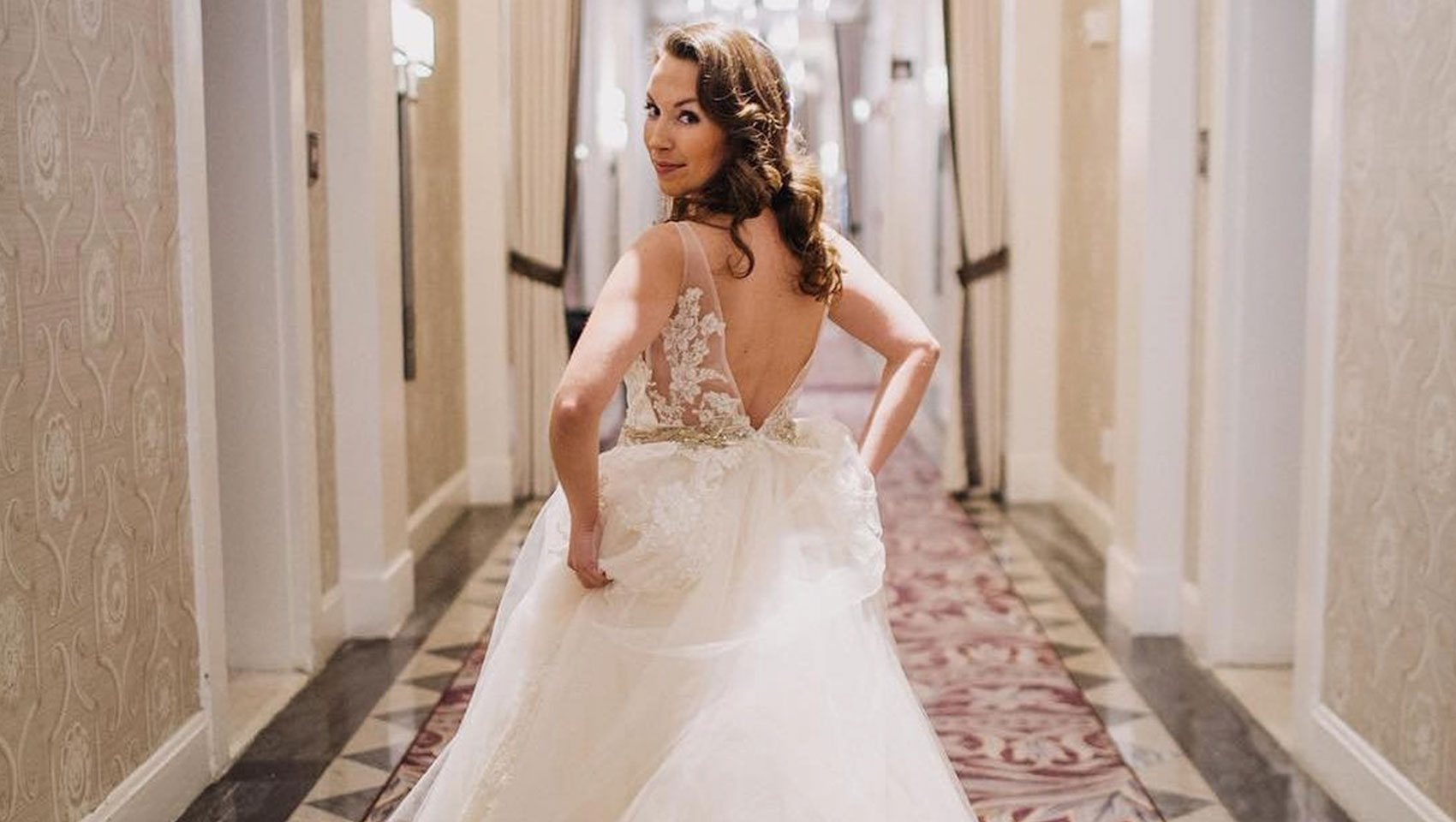 bride walks down hallway and looks back at camera at Kimpton Hotel Monaco Washington DC