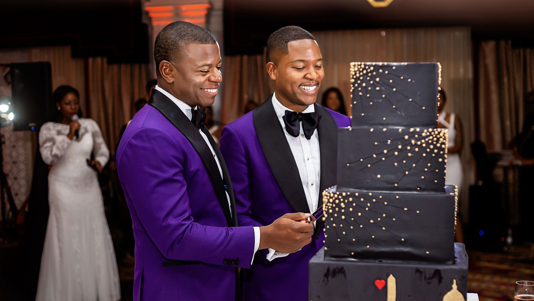 Grooms cut their wedding cake in the Paris Ballroom at Kimpton Hotel Monaco Washington DC