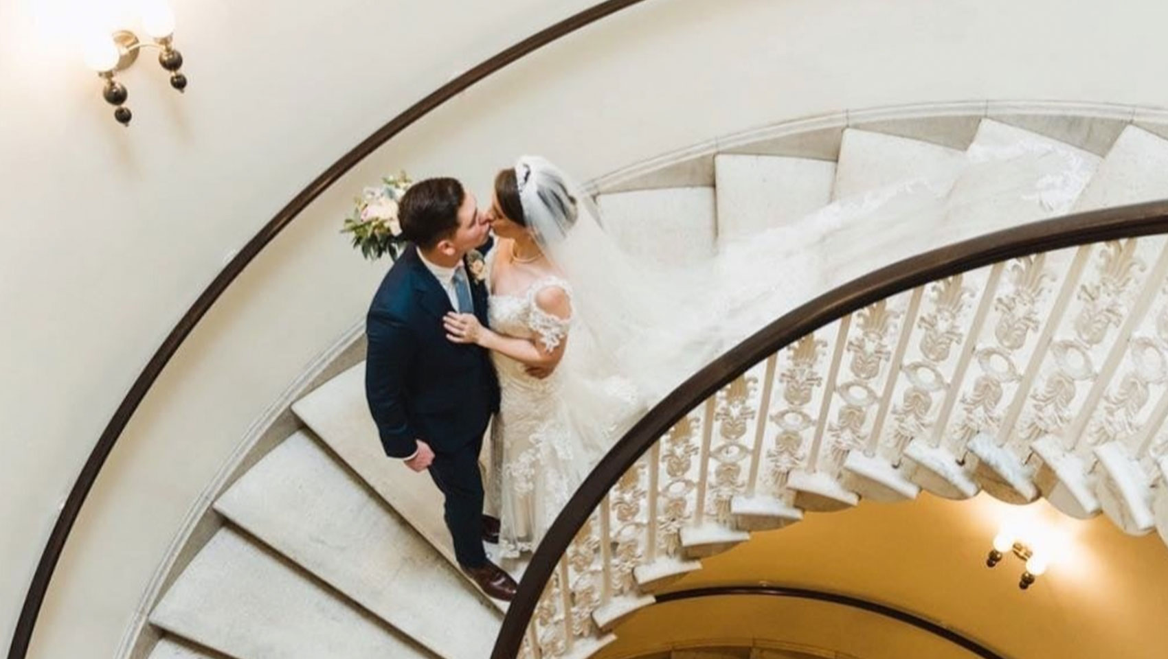 bride and groom kiss on the marble staircase at Kimpton Hotel Monaco Washington DC