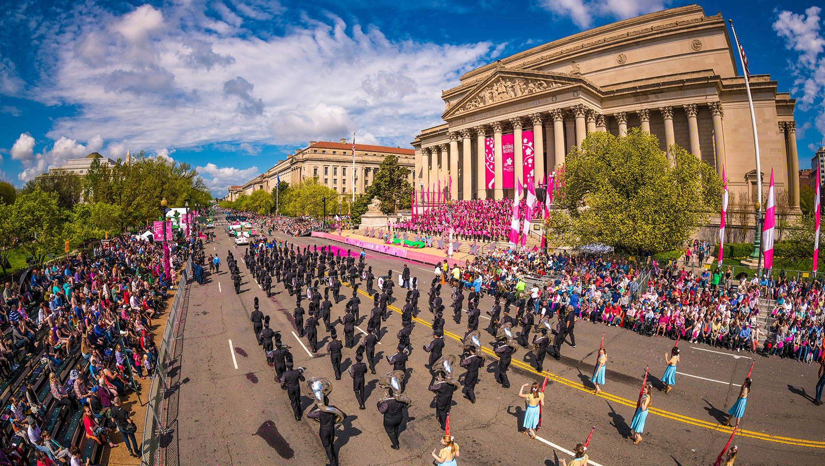 cherry blossom festival parade walks down street in washington dc